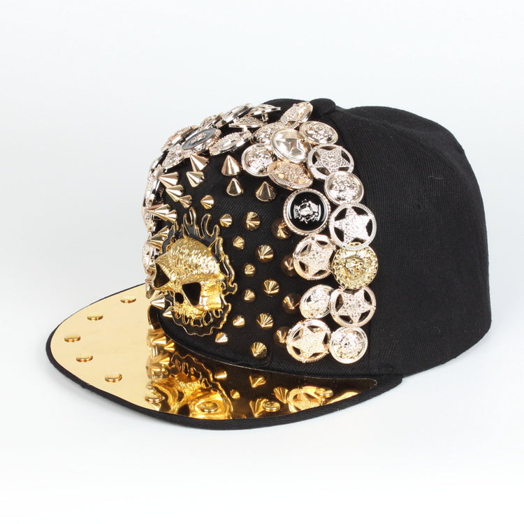 Black baseball cap with gold brim and ornate rhinestone skull face on side