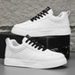 White sneakers with black lace-up accents and textured white sole