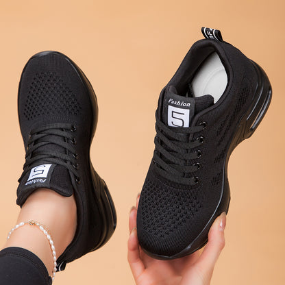 Black knit mesh lace-up sneakers held in hands with air-cushion sole