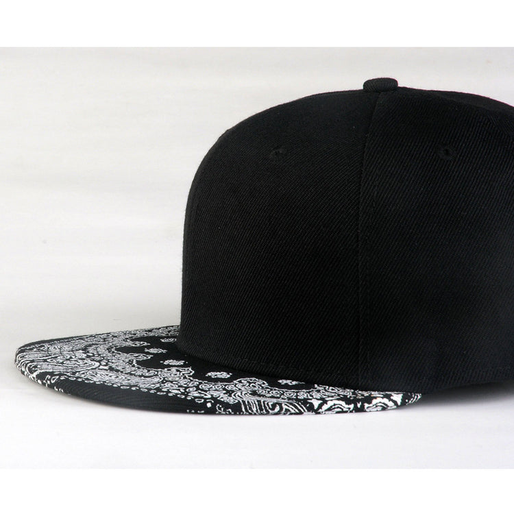 Black baseball cap with white paisley print brim, flat profile