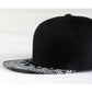 Black baseball cap with white paisley print brim, flat profile