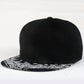 Black baseball cap with white paisley print brim, curved crown seams