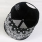 Black baseball cap with paisley brim; interior mesh panel and button