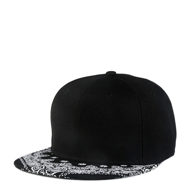 Black baseball cap with white paisley print flat brim and button top