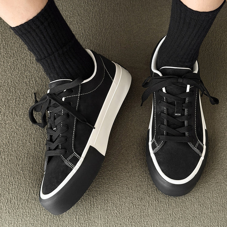 Black low-top sneakers with lace-up closures and white trim, side-by-side view