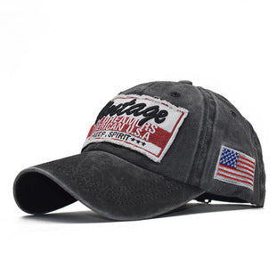 Dark baseball cap with embroidered USA flag patch and front graphic badge, curved brim