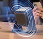 Black folding phone stand speaker with perforated speaker grille beneath phone