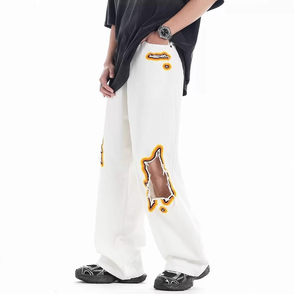 Loose white trousers with ripped embroidery patches and wide-leg fit