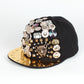 Black baseball cap with gold brim, rhinestone charms and leopard-style face detail