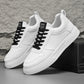 White sneakers with black lace-up details and textured white sole