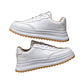 White lace-up sneakers with chunky sole, tan accents, and stitched paneling