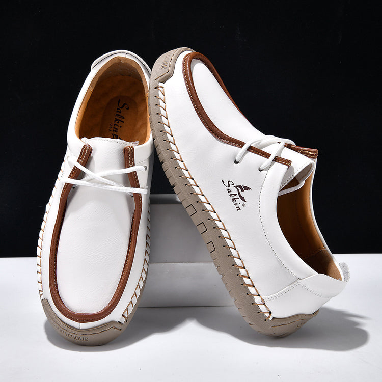 White lace-up casual shoes with brown trim and lace, stitched moccasin-style upper.