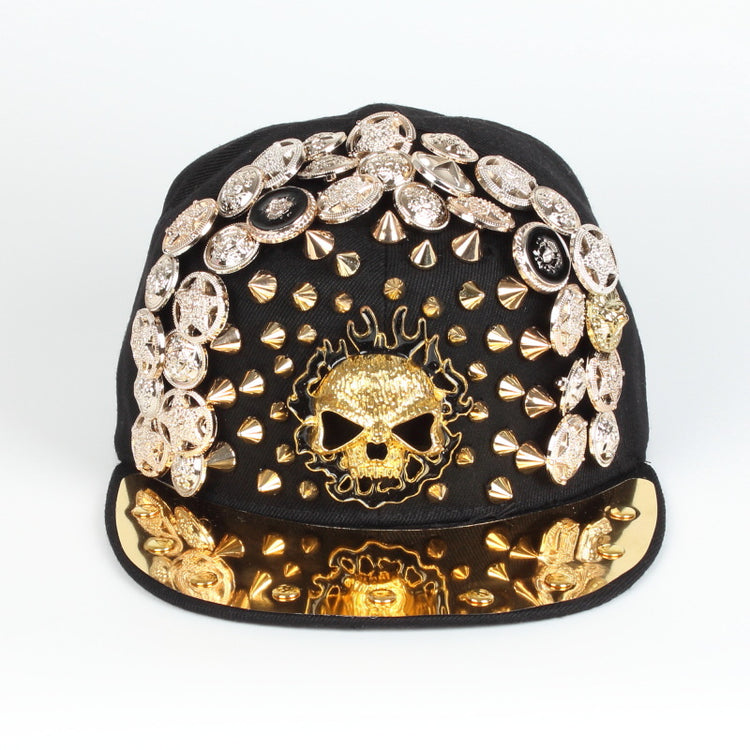 Black baseball cap with gold rhinestone skull detail, spike studs, and decorative brim