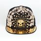 Black baseball cap with rhinestone skull patch, spike studs, and gold brim