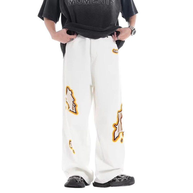 Loose white trousers with multiple ripped embroidery patches and wide-leg shape
