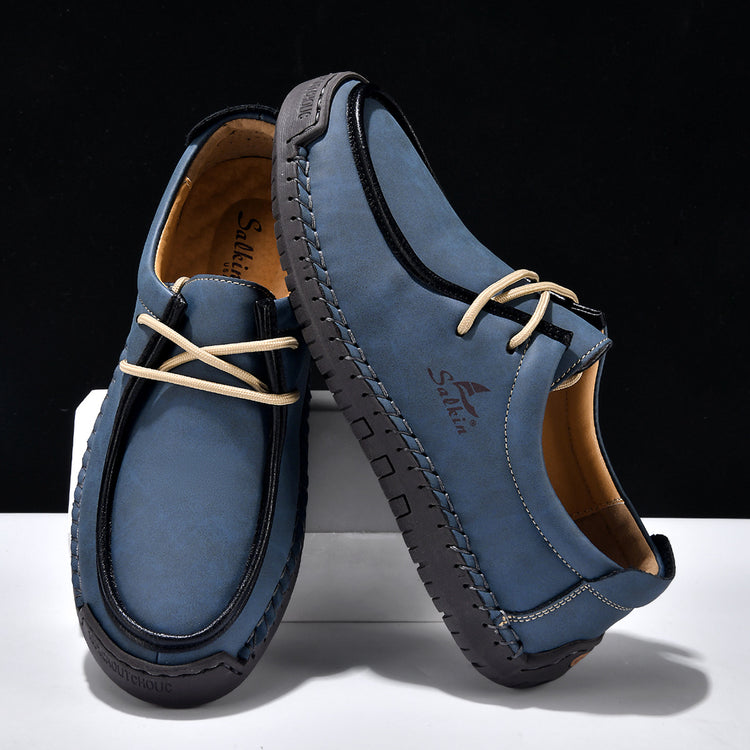 Dark blue lace-up casual shoes with cream laces, stitched moccasin-style upper.