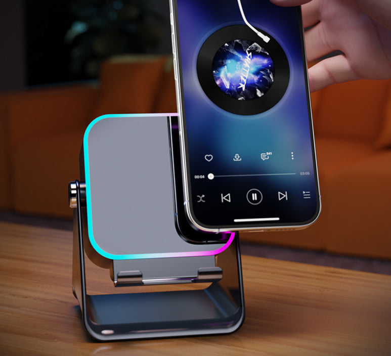 Black phone stand with wireless speaker; RGB light on charging cradle