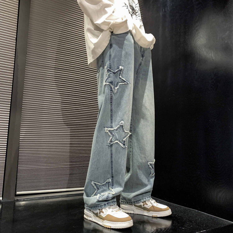 Light blue denim straight-leg pants with star appliques and distressed patches
