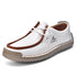 White lace-up casual shoes with brown trim and white laces, stitched moccasin-style upper.