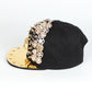 Black baseball cap with gold underside brim, rhinestone skull band and spike studs