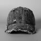 Washed denim baseball cap with distressed crown and frayed brim, dark wash.