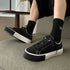 Black low-top sneakers with lace-up, white sole, and thick platform heel