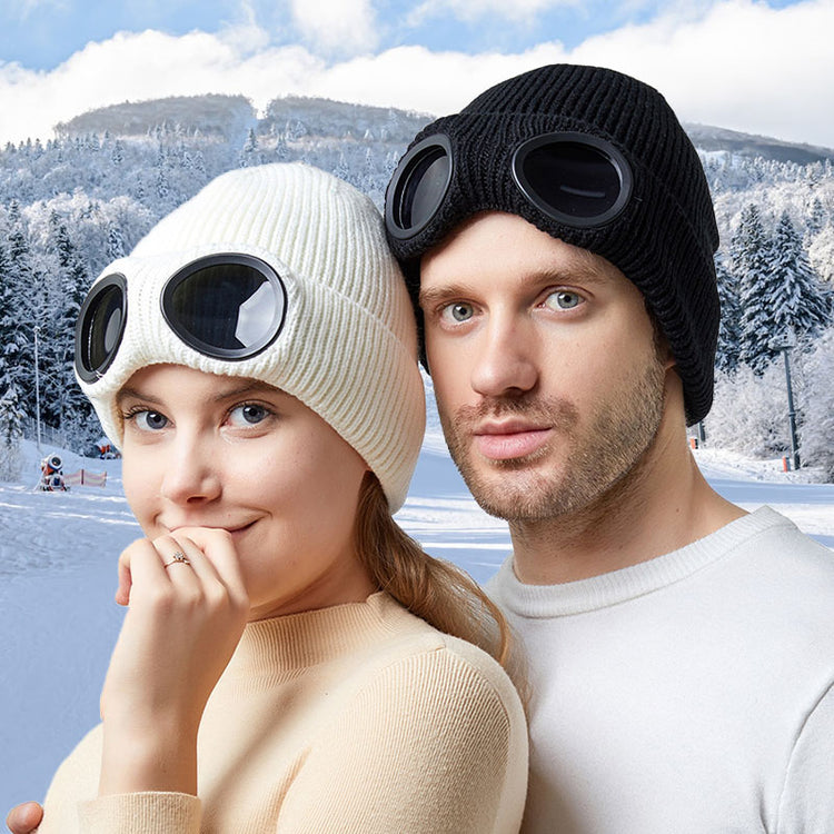 Two knitted beanies with windproof eye shields, one white and one black