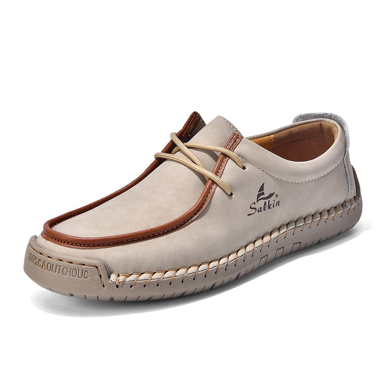 Light beige lace-up casual shoes with brown trim and cream laces, stitched upper.