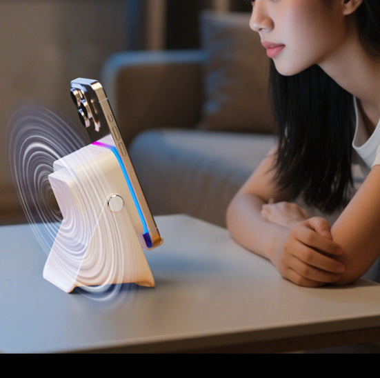 Wireless phone stand speaker on desk; smartphone charging with ambient light