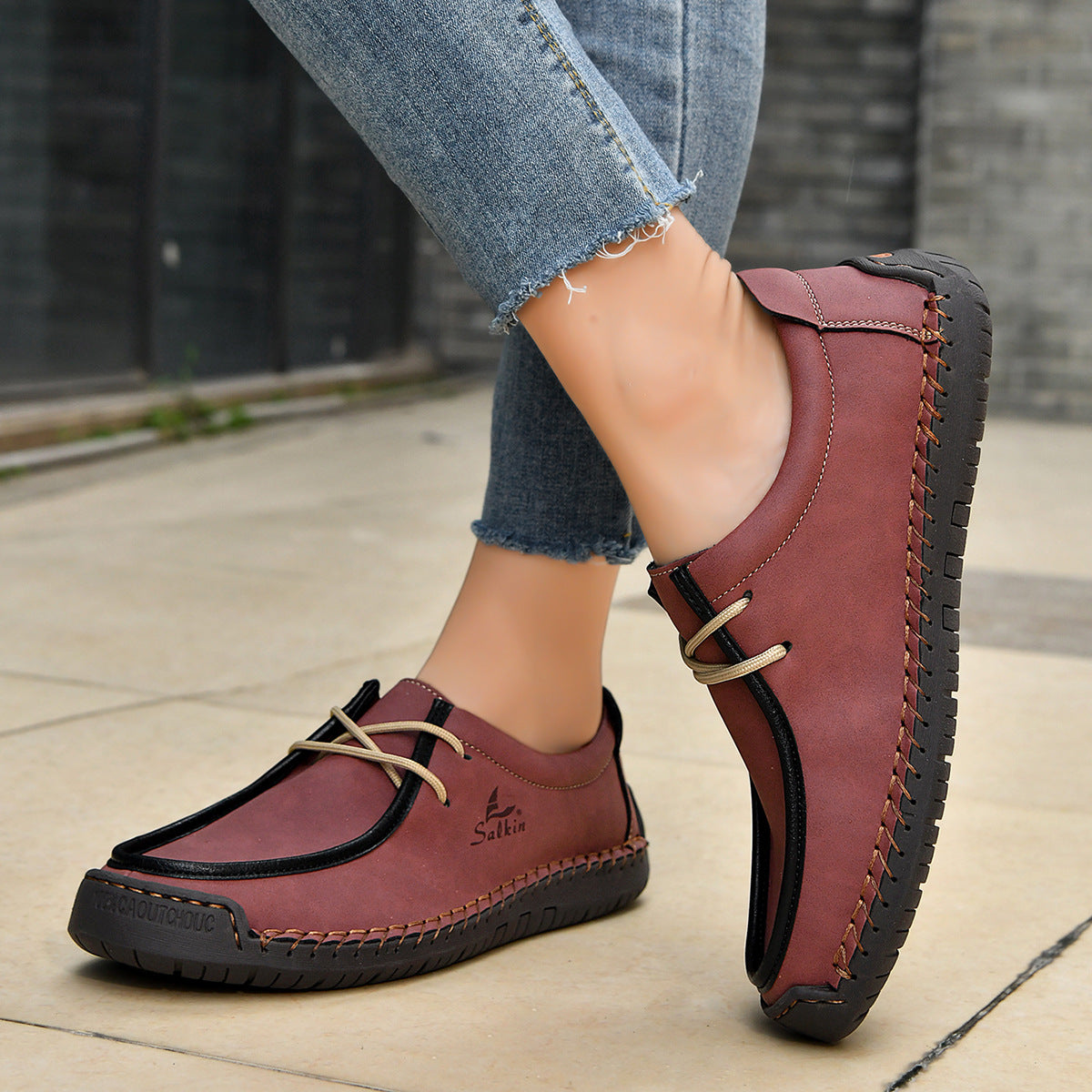 Wine red lace-up casual shoes with black soles, stitched moccasin-style upper.