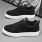 Black sneakers with white sole and lace-up front