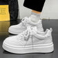 Pair of white height-increasing sneakers with patterned side panels and thick rubber platform sole