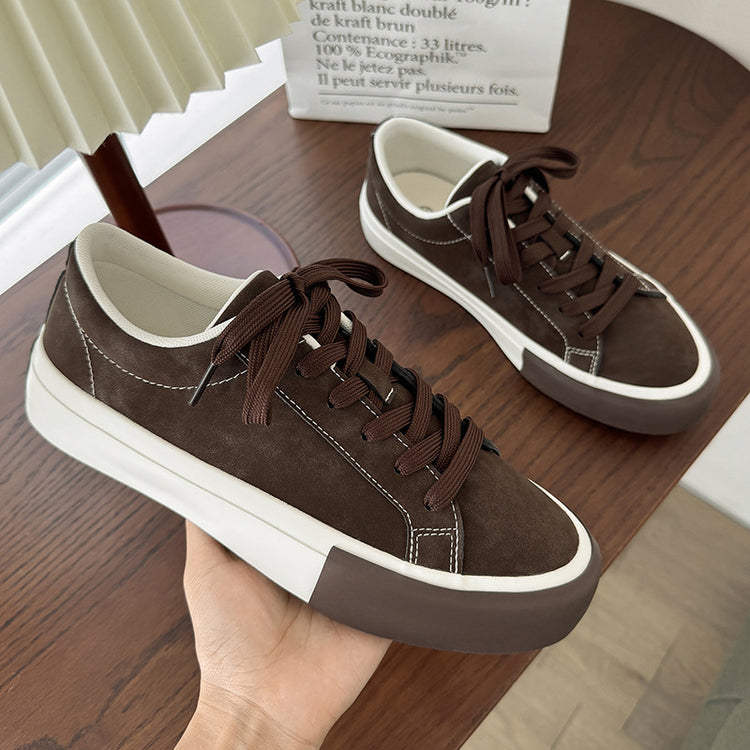 Brown low-top sneakers with lace-up front, white sole, and contrast stitched panels