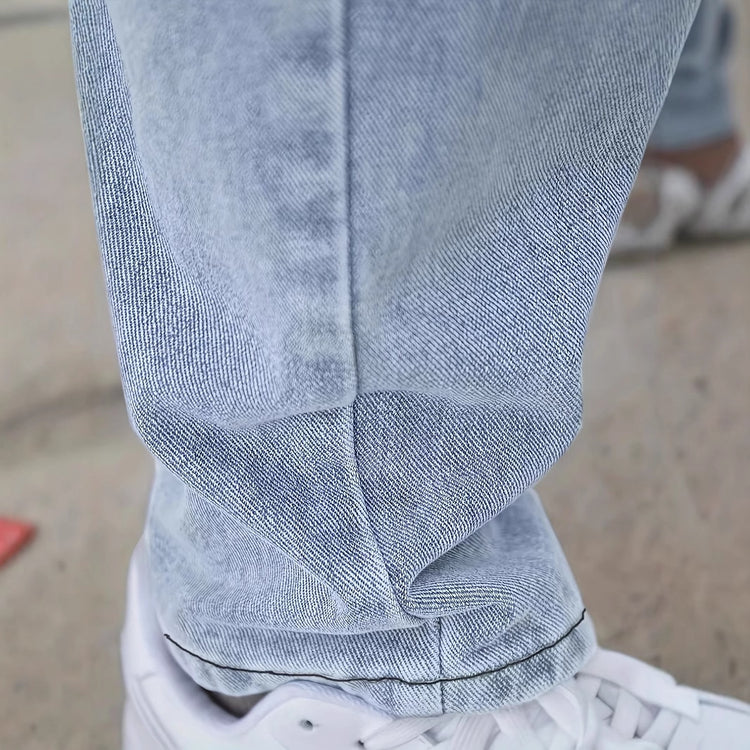 Light blue denim jeans cuff with creased wash and visible hem stitching