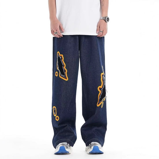 Loose dark denim trousers with ripped embroidery patches and wide-leg fit