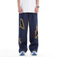 Loose dark denim trousers with ripped embroidery patches and wide-leg fit
